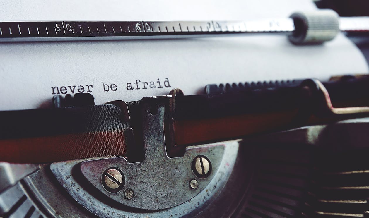 Close-up of a typewriter with the phrase "never be afraid" typed on paper.